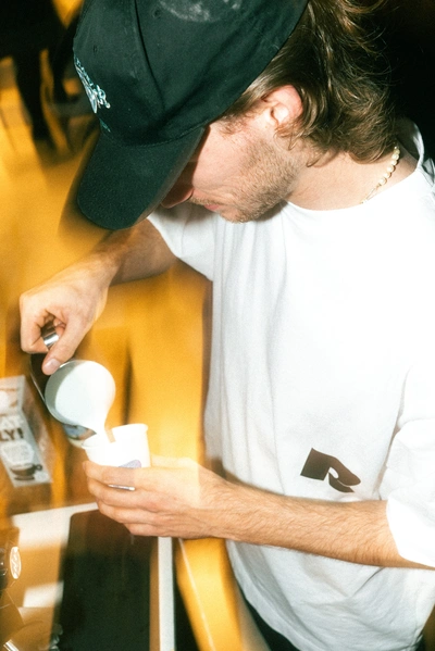 Barister macht Latte Art in einen Becher mit dem Raum Logo